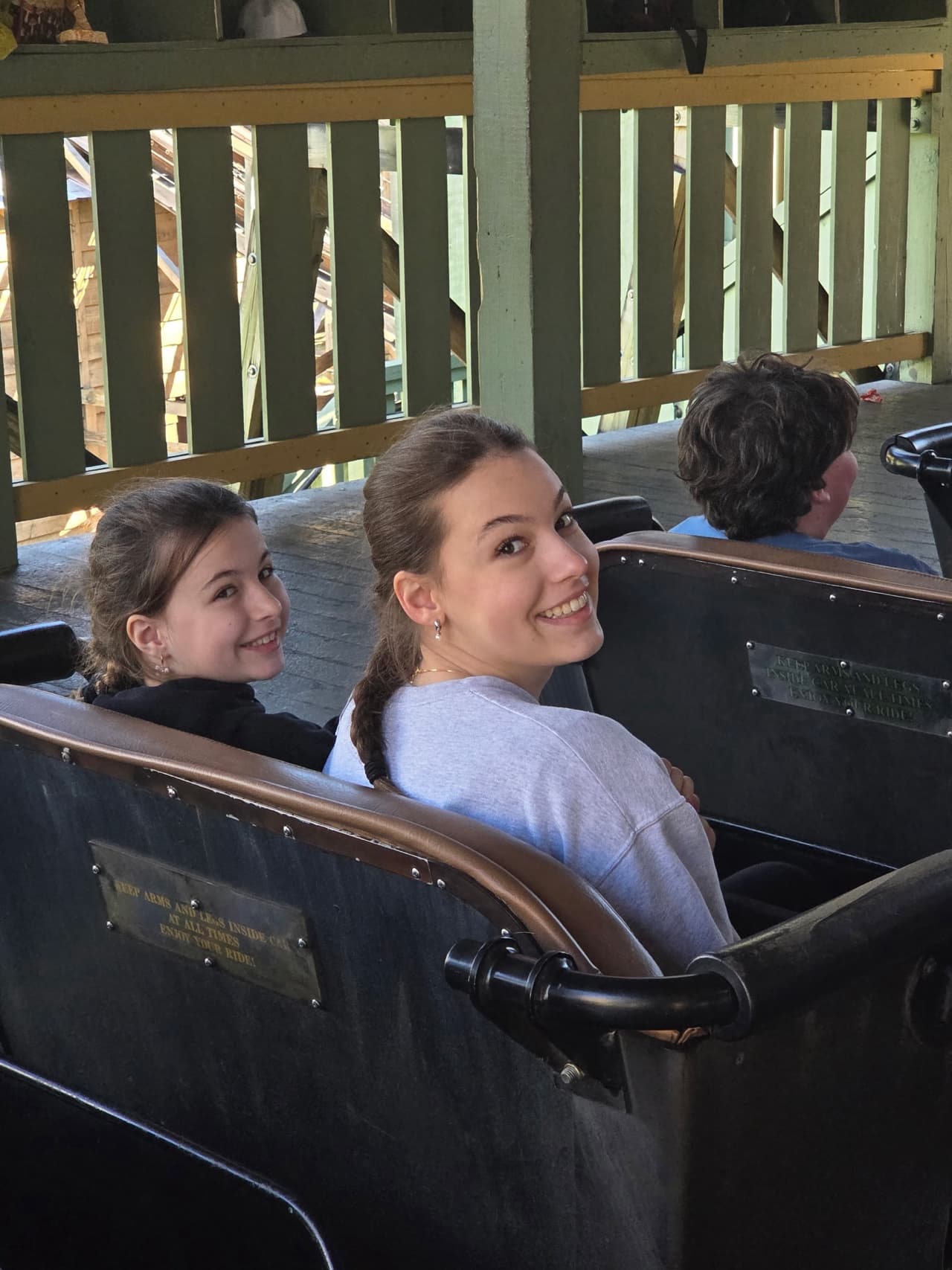 Lyla and her younger sister on a wooden roller coaster